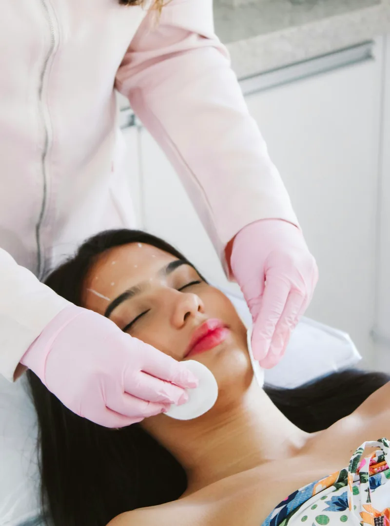 Manos aplicando crema facial con suavidad, de cerca